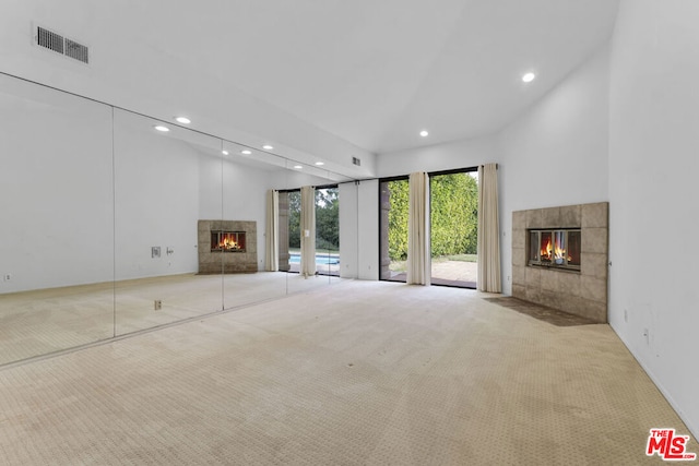 unfurnished living room featuring a fireplace, a high ceiling, and light colored carpet