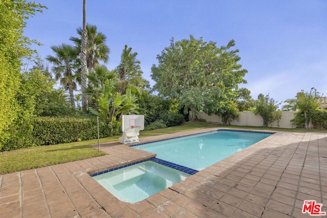 view of pool featuring an in ground hot tub, a yard, and a patio