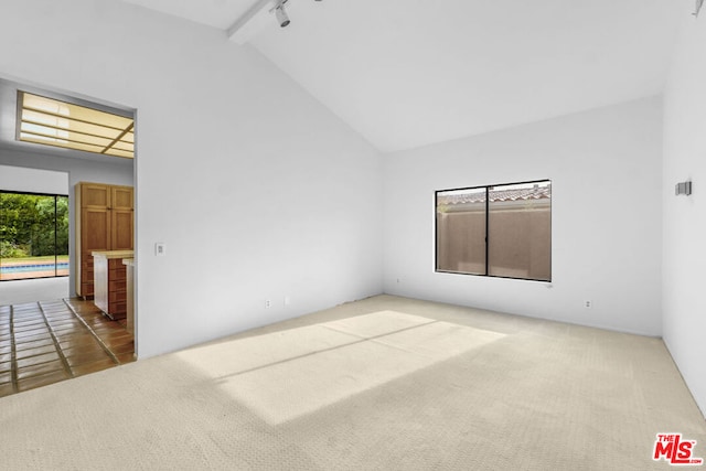 unfurnished room featuring carpet flooring, beamed ceiling, high vaulted ceiling, and track lighting