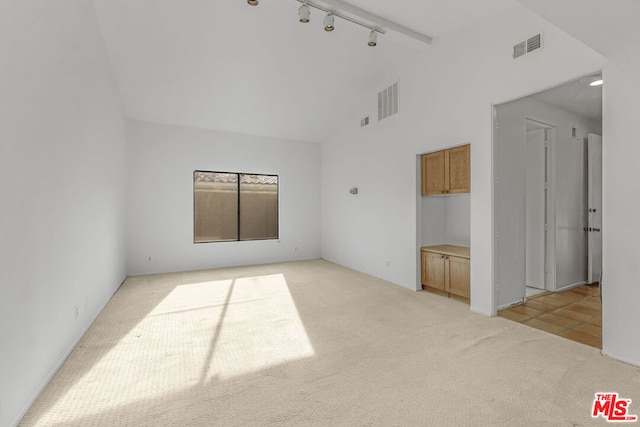 carpeted spare room featuring beam ceiling, high vaulted ceiling, and track lighting