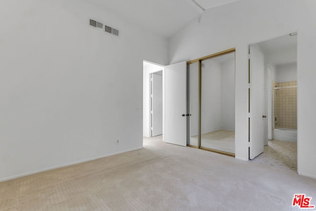 unfurnished bedroom featuring light colored carpet and a closet