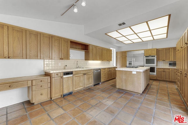 kitchen featuring decorative backsplash, a kitchen island, stainless steel appliances, and vaulted ceiling