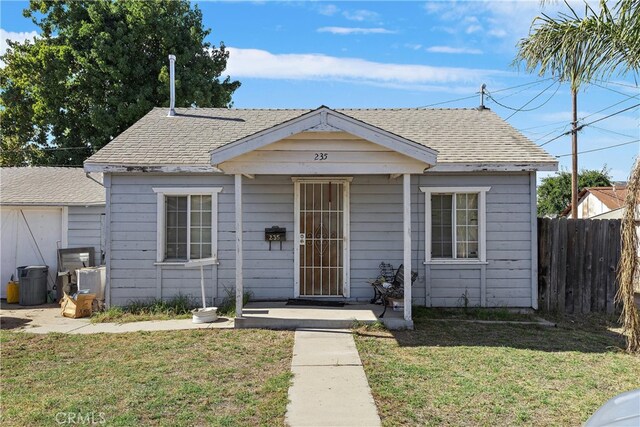 bungalow-style home with a front yard