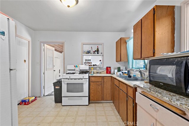 kitchen featuring white range with gas cooktop and sink