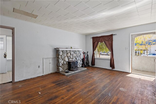 unfurnished living room with dark hardwood / wood-style floors and a wood stove