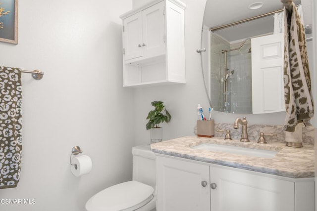 bathroom with vanity, toilet, and a tile shower