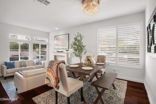 dining room featuring a chandelier, dark hardwood / wood-style flooring, and a wealth of natural light