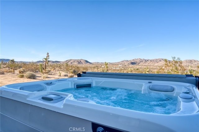 view of swimming pool featuring a hot tub and a mountain view