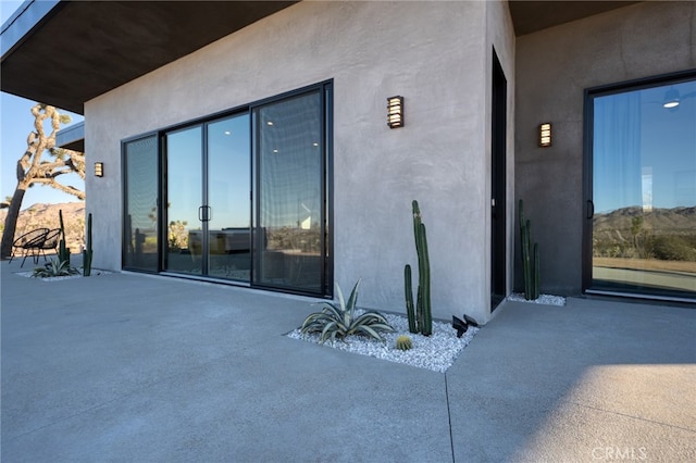 view of exterior entry with a patio