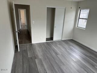 unfurnished bedroom featuring a closet and dark hardwood / wood-style flooring