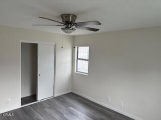 unfurnished bedroom with ceiling fan, dark hardwood / wood-style floors, and a closet