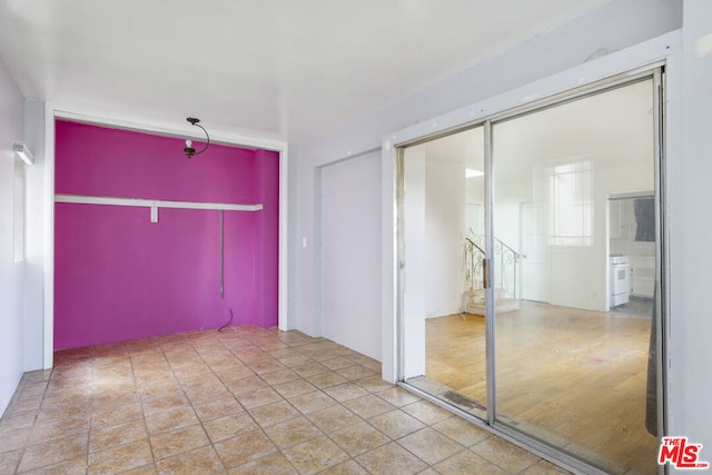 interior space with connected bathroom, hardwood / wood-style flooring, and a closet