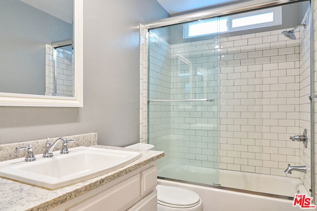 full bathroom featuring toilet, vanity, and combined bath / shower with glass door