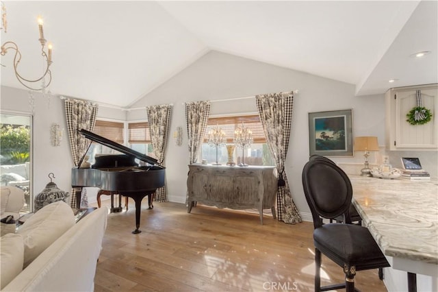 living area with hardwood / wood-style floors and high vaulted ceiling