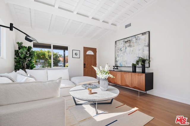 living room featuring light hardwood / wood-style floors, high vaulted ceiling, and beam ceiling