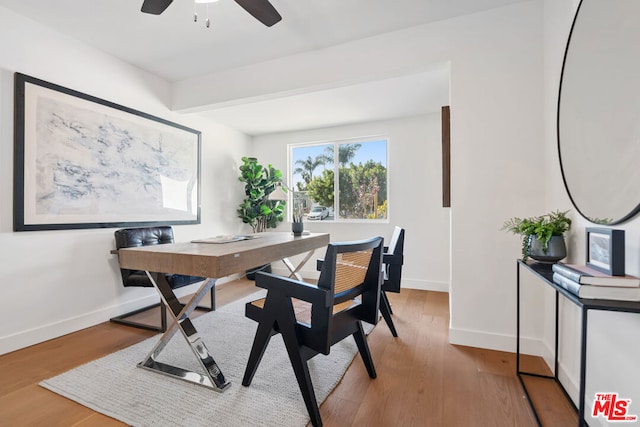 home office with ceiling fan, light hardwood / wood-style floors, and beamed ceiling