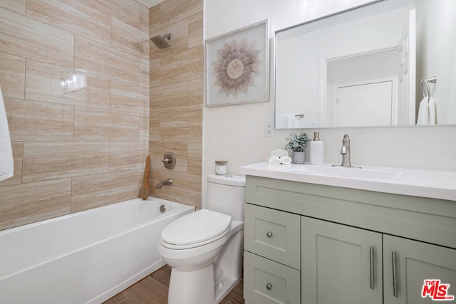 full bathroom with toilet, vanity, and tiled shower / bath