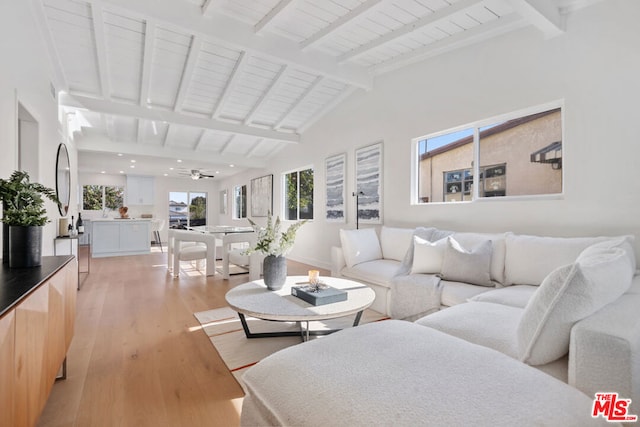 living room with a wealth of natural light, wood ceiling, light hardwood / wood-style flooring, and lofted ceiling with beams