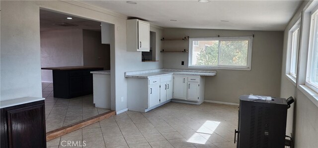 kitchen featuring lofted ceiling, white cabinets, and light tile patterned floors