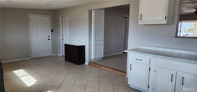 kitchen with white cabinetry, ceiling fan, and light tile patterned floors