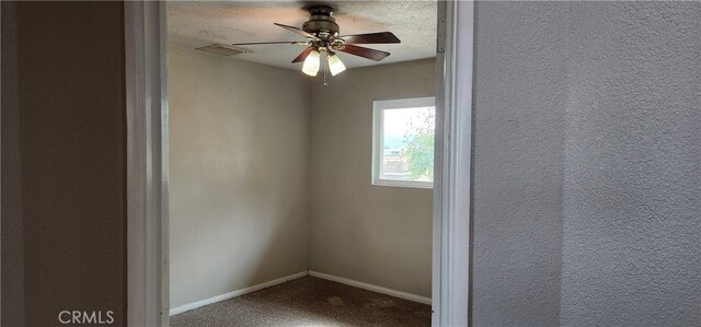 spare room with ceiling fan, a textured ceiling, and carpet floors