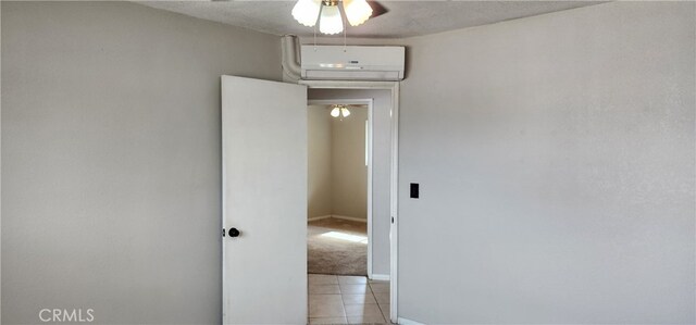 interior space featuring a wall mounted AC, a textured ceiling, and light tile patterned floors