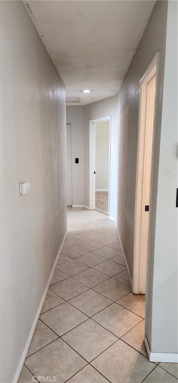 hall featuring light tile patterned floors