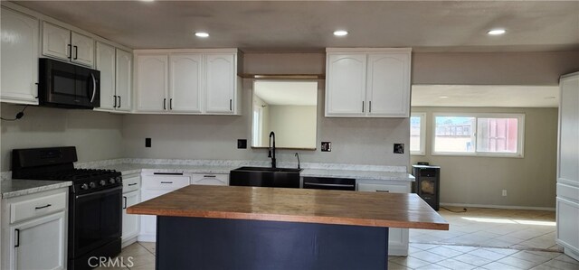 kitchen featuring sink, black appliances, butcher block counters, and white cabinets