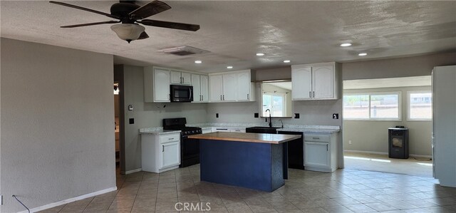 kitchen featuring a kitchen island, a textured ceiling, white cabinetry, black appliances, and sink