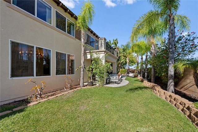 view of yard featuring a balcony and a patio