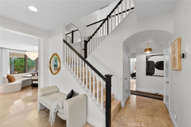 staircase featuring a chandelier