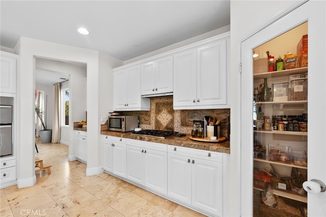 kitchen with white cabinets, stainless steel appliances, and tasteful backsplash