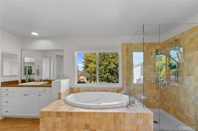 bathroom featuring vanity and independent shower and bath