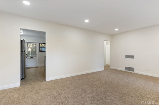 spare room featuring light colored carpet