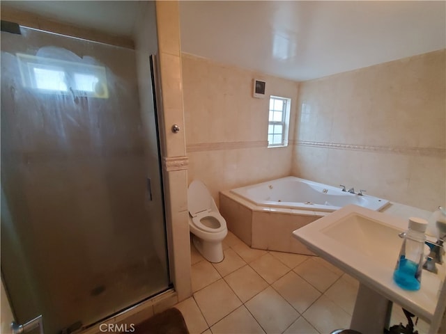 bathroom featuring toilet, tile patterned floors, tile walls, and shower with separate bathtub