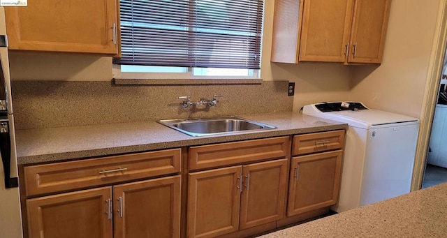 kitchen with washer / dryer, tasteful backsplash, and sink