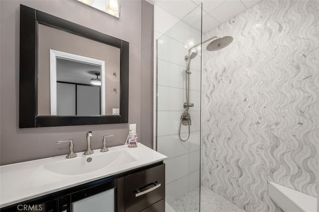 bathroom with vanity and a tile shower