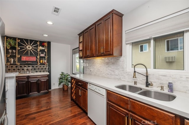 kitchen featuring white dishwasher, sink, dark hardwood / wood-style flooring, and tasteful backsplash