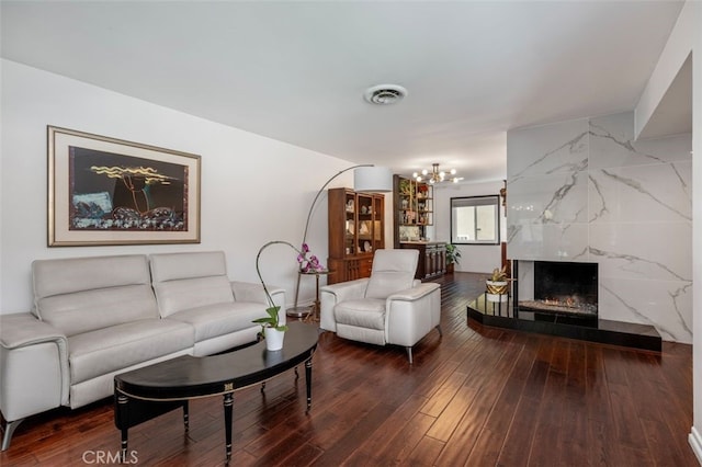 living room featuring wood-type flooring, a fireplace, and a chandelier