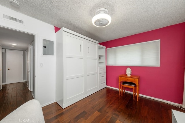 bedroom featuring dark wood-type flooring, a closet, and a textured ceiling