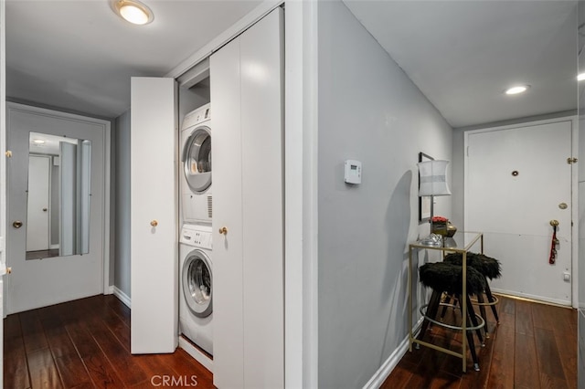 washroom featuring stacked washer / drying machine and dark hardwood / wood-style floors