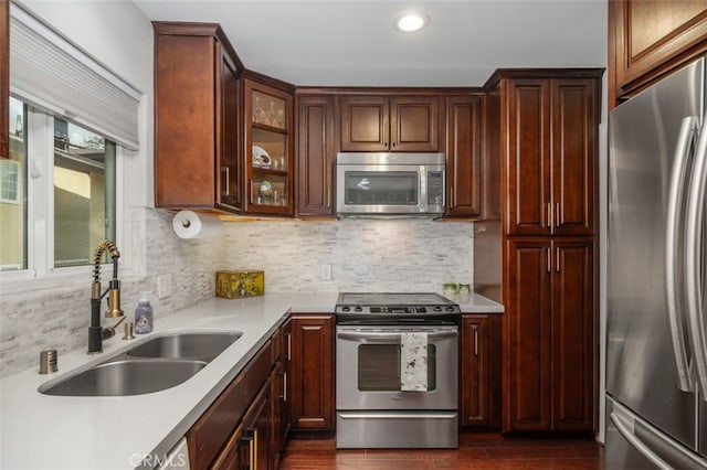 kitchen featuring stainless steel appliances, sink, and backsplash