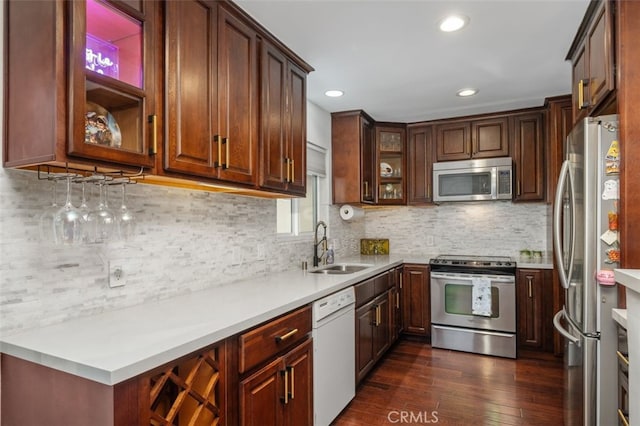 kitchen with stainless steel appliances, dark hardwood / wood-style floors, sink, and backsplash