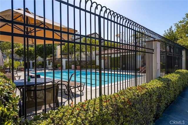 pool with a patio area and fence