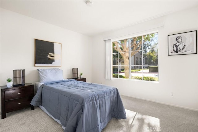 bedroom with baseboards and light colored carpet