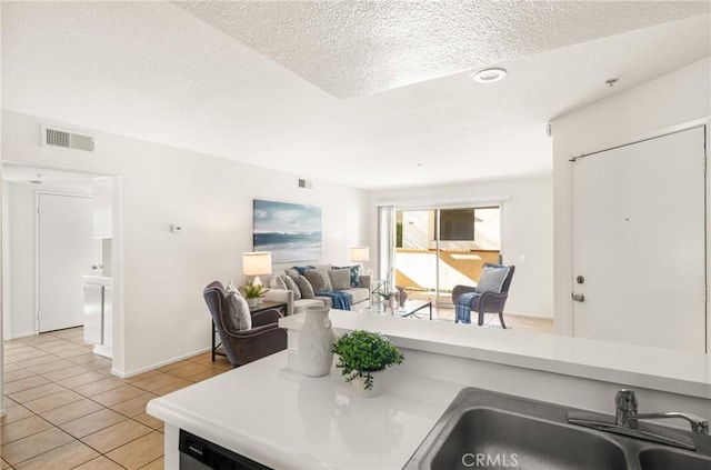 kitchen featuring light tile patterned floors, a textured ceiling, and sink