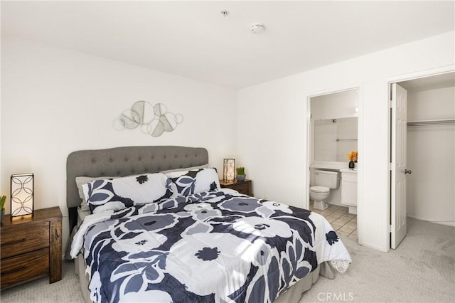 carpeted bedroom featuring ensuite bathroom, a walk in closet, and a closet