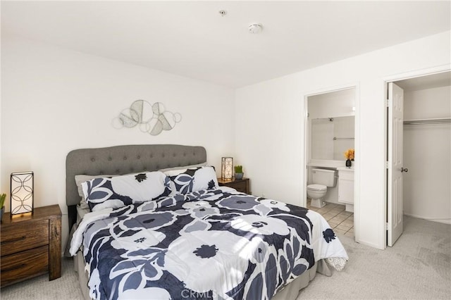 bedroom featuring light carpet and connected bathroom