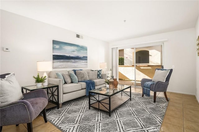 tiled living room with visible vents and baseboards