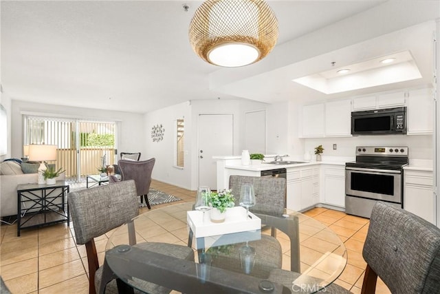 kitchen with white cabinets, black microwave, light countertops, and stainless steel range with electric cooktop